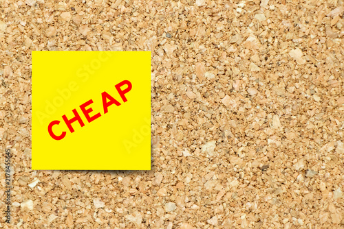 Obraz na płótnie Yellow note paper with word cheap on cork board background with copy space