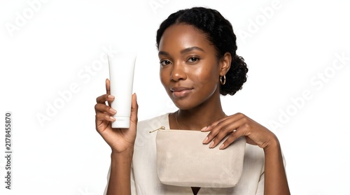 Beautiful young woman holding a blank white cosmetic tube and a small pouch.