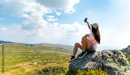 Beautiful Woman taking selfie pictures with her phone in the mountain 