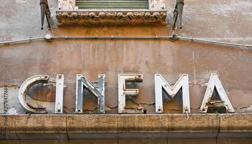 Weathered vintage cinema sign on old building facade in Verona, Italy