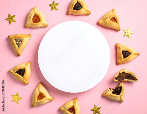 Overhead shot of baked triangular pastries with filling, surrounding a white circle on pink