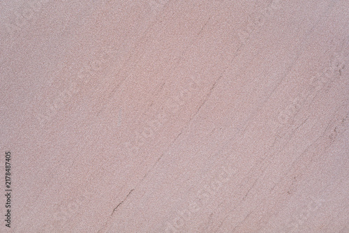 Full frame background texture of sharp bright pink sand stone surface with subtle diagonal grain lines