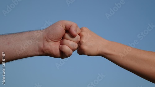 Male and woman fists against sky, trust, harmony, friendship. Fist to fist sign, expresses consent, gesture of respect. Teamwork concept. Lifestyle business team clenching their fists, Hands closeup