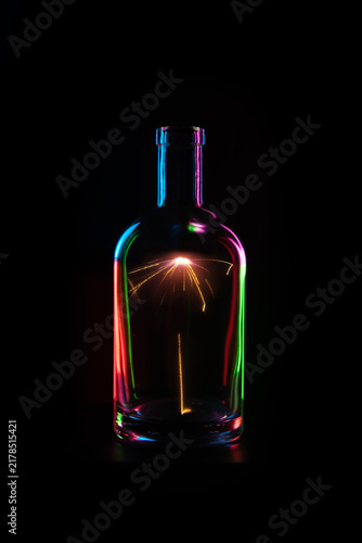 Photography Glass bottle with neon reflections and spark light painting
