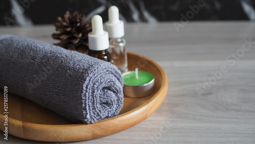Konstfotografi Gray rolled spa towel with green tealight candle and essential oil bottles on a wooden tray, creating a calm wellness, aromatherapy, relaxation and self care concept with copy space