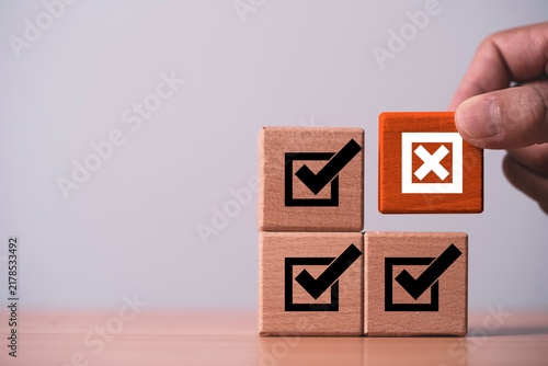 Fotografía Quality control concept showing check marks and a rejected choice as a hand identifies an error during inspection to represent verification, compliance, evaluation and business quality assurance