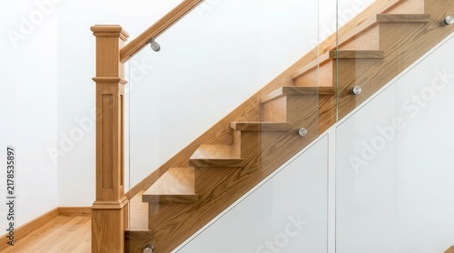 Solid newel post stairs featuring wooden treads and transparent glass railing held by steel frames