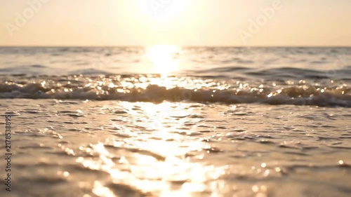 Ocean waves rolling onto a sandy beach at sunset with golden sunlight reflecting on water with waves crashing video ocean reflection splashing shoreline seashore with during sunset