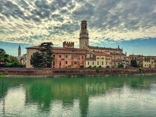 Fotografía THE ADIGE RIVER IN VERONA ITALY WITH A ROW OF OLD WELL KEPT HOMES AND A BELL TOW