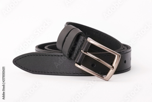 Black stitched leather belt rolled up with a classic metal buckle isolated on a white background