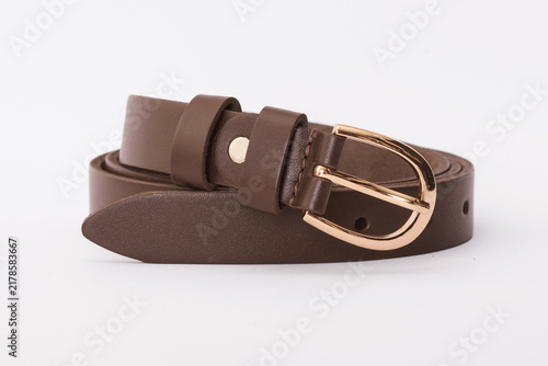 Brown smooth leather belt coiled with a rounded gold buckle on a white background