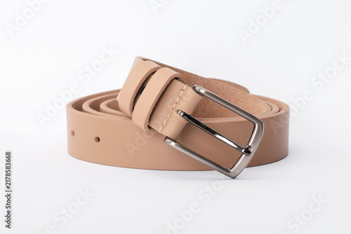 Beige smooth leather belt coiled with a classic rectangular metal buckle on a white background