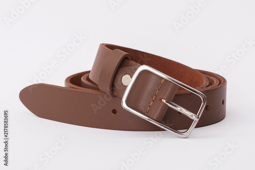 Light brown smooth leather belt coiled with a rectangular silver metal buckle on a white background
