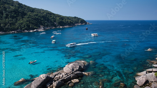 Фотография Turquoise gradient water and granite boulders with tour boats anchored at Donald