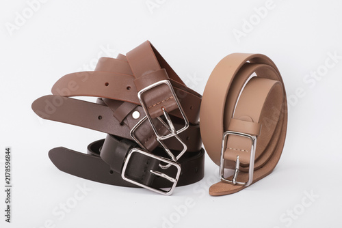 Set of brown beige and dark brown leather belts with silver metal buckles on a white background