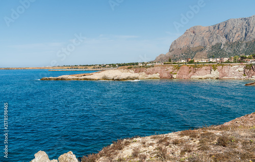 Scenic view of the Terrasini coast, a seaside town in the province of Palermo, Sicily, Italy, characterized by rugged rocky cliffs and crystal-clear waters of the Mediterranean Sea.