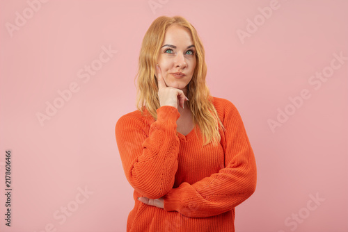Bild auf Leinwand Young adult woman posing with hand on chin and looking up, deeply concentrating