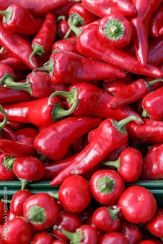 Bild auf Leinwand Fresh ripe red hot chili peppers and raw Capsicum annuum harvested for spicy culinary ingredients at an outdoor street market display in natural daylight, vertical shot, Warsaw, Poland