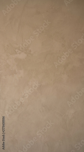 A high quality vertical background featuring a smooth beige concrete wall with subtle artistic plaster textures and soft natural lighting for modern interior design project mockups