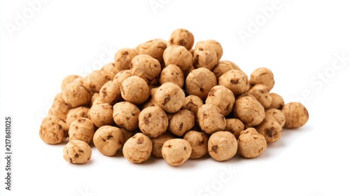 A pile of raw organic tiger nuts, also known as chufa or earth almonds, isolated on a white background.