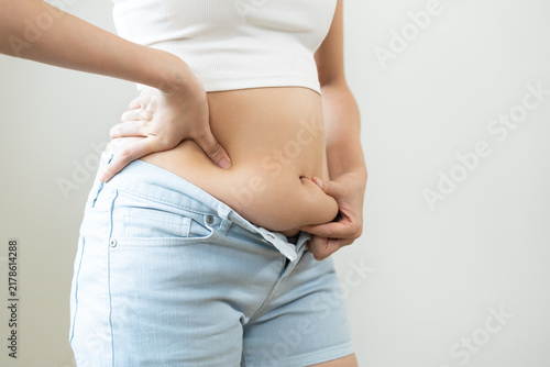 Foto Weight gain, overweight, high cholesterol and pressure, woman hand pinching exce