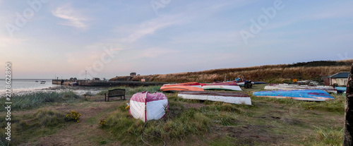 Obraz na płótnie Small boats hauled ashore at Lindisfarne Harbour, dusk sky