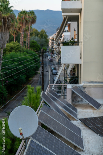 Balcony solar panels installation and satellite dish on apartment building in urban city area