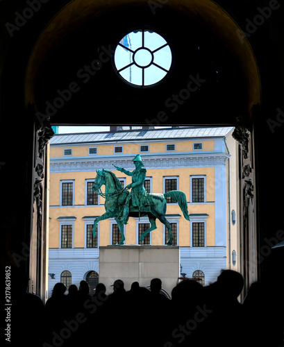 View through a gateway of the Royal Palace in Stockholm towards the street Slottsbacken and the equestrian statue of Charles XIV John, the former King of Sweden and Norway