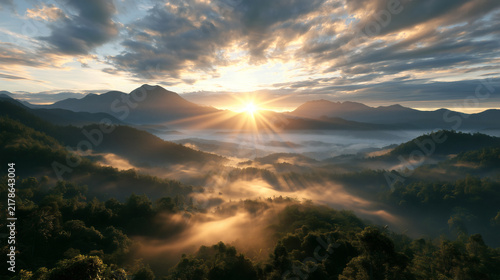 Bright Mountain Sunrise with Radiant Sunbeams over Foggy Valley