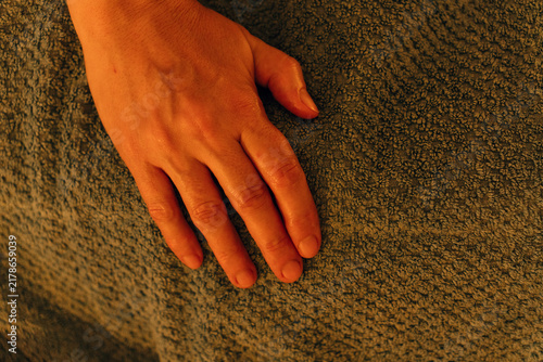 фотографія A therapist hand rests on a towel covering a woman during spa treatment
