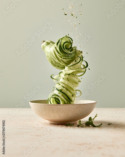 Pale-Green Chayote Squash Ribbons with Seasoning Sprinkles in a Ceramic Bowl