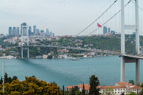 Bridge over water, connecting modern city with natural landscape, cloudy day