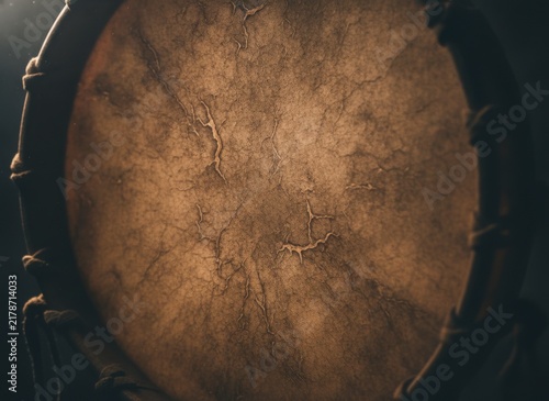 Close-up of a rustic drumhead with textured leather surface and dark background