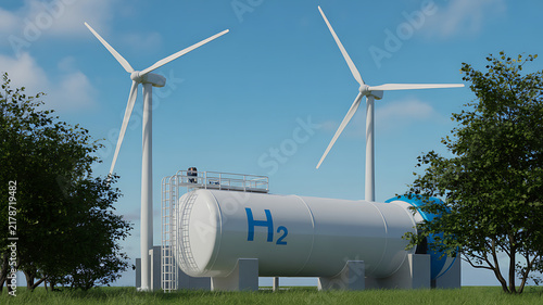 Industrial hydrogen storage tank with h2 branding situated in a green field with two large wind turbines under blue sky.