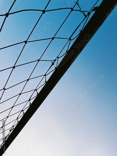 Soccer ball net frame against a clear bright blue sky creating an inspirational mood of outdoor sports