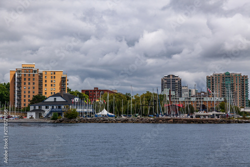 ONTARIO, CANADA - A view of Kingston city and the coastline from lake Ontario, on an overcast and calm summer day