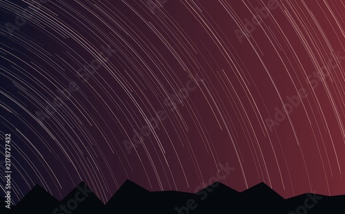 Fotografie Stunning star trails over a dark mountain silhouette at night