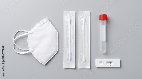 Fototapeta kuchenna Rapid Antigen Test Kit with Nasal Swabs, Face Mask, and Tube on Gray Background