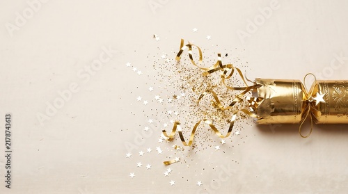 Festive Celebration Background with Golden Party Popper, Confetti and Streamers
