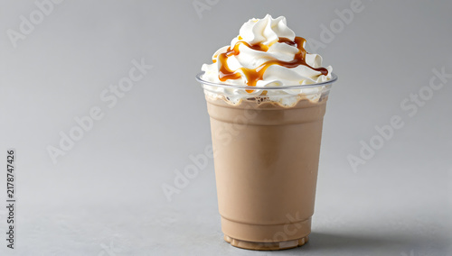 Caramel Frappe Delight: A refreshing caramel frappe, topped with whipped cream and a generous drizzle of caramel sauce, served in a clear plastic cup, perfect for a cool indulgence.