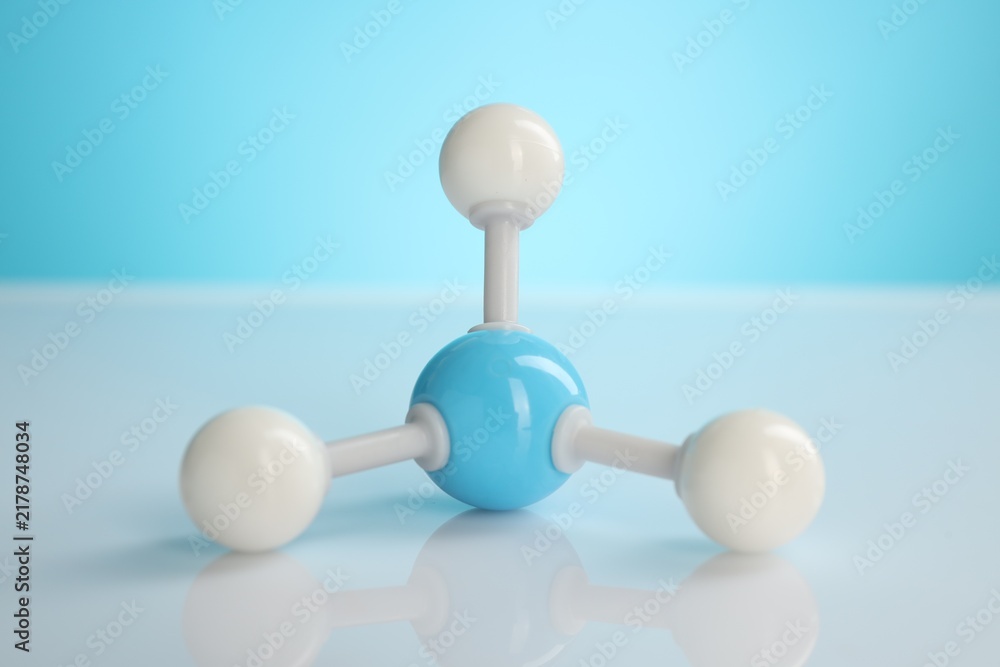 Obraz premium Chemical model of molecule on white table against light blue background, closeup
