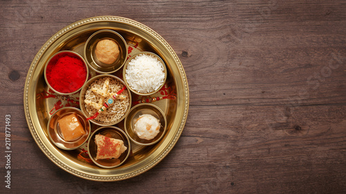 Traditional Diwali pooja thali with sweets and diyas on wooden table