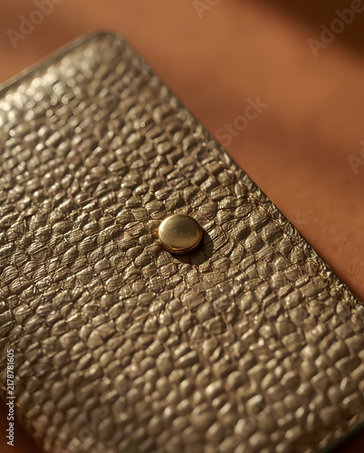 Close up of metallic gold textured leather wallet with snap button fastener