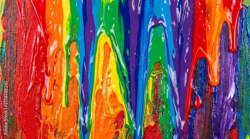 Vibrant rainbow acrylic paint dripping on canvas texture abstract background