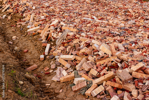 Foto Rural road base under construction covered with crushed red and yellow bricks an