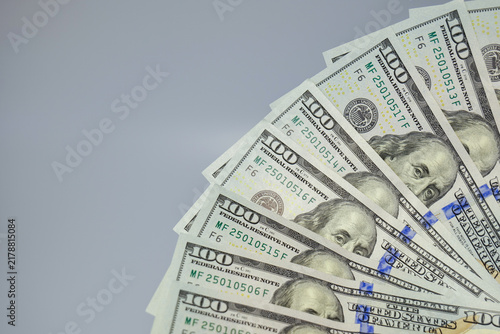 Obraz na płótnie High angle shot of hundred dollar bills spread in a semicircular fan layout on a white table