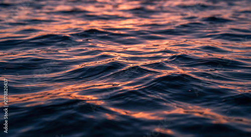 Dark Ocean Water Surface Texture With Sunset Reflection Background
