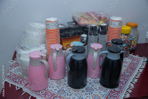 Coffee break table setting with thermal flasks, paper cups, candies, The table is neatly arranged with beverage supplies and snacks for guests during a conference break.