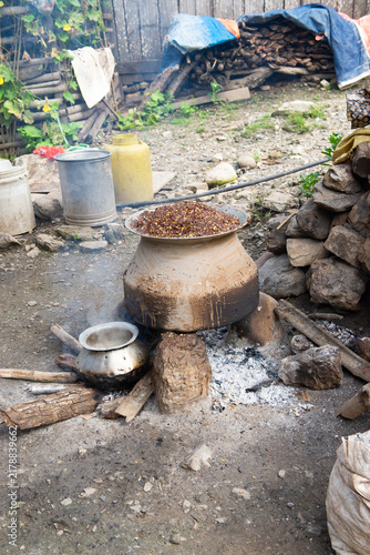 Vertical image of Traditional outdoor cooking using rustic, aged pots in Chitwan, Nepal in vertical format
