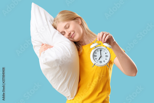 Foto Sleep deprivation and morning fatigue, young woman holding alarm clock and pillo